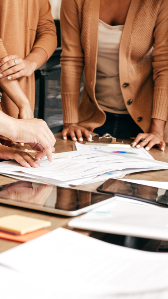 Group of marketers leaning over table