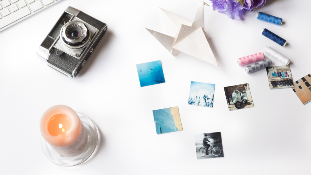 old school camera, scattered photos, a candle, and origami