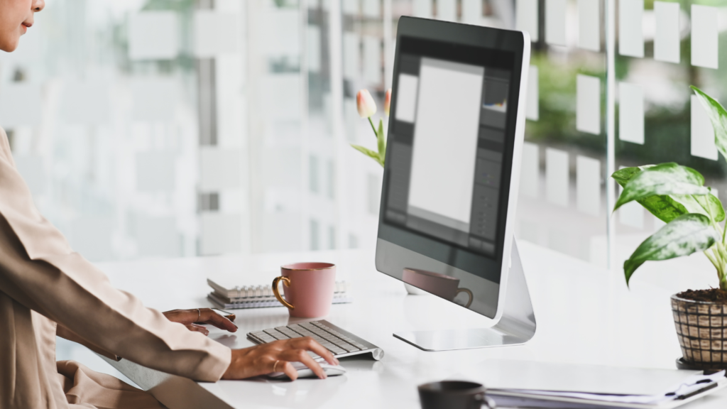 Woman standing while working on iMac